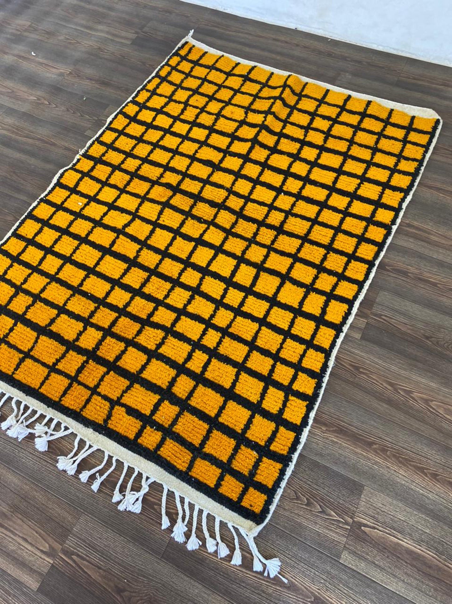 Tapis marocain tissé à la main jaune et noir quadrillé.