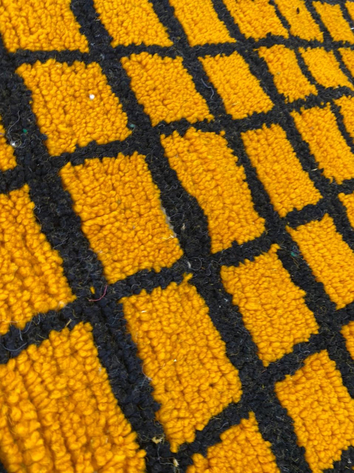 Tapis marocain tissé à la main jaune et noir quadrillé.