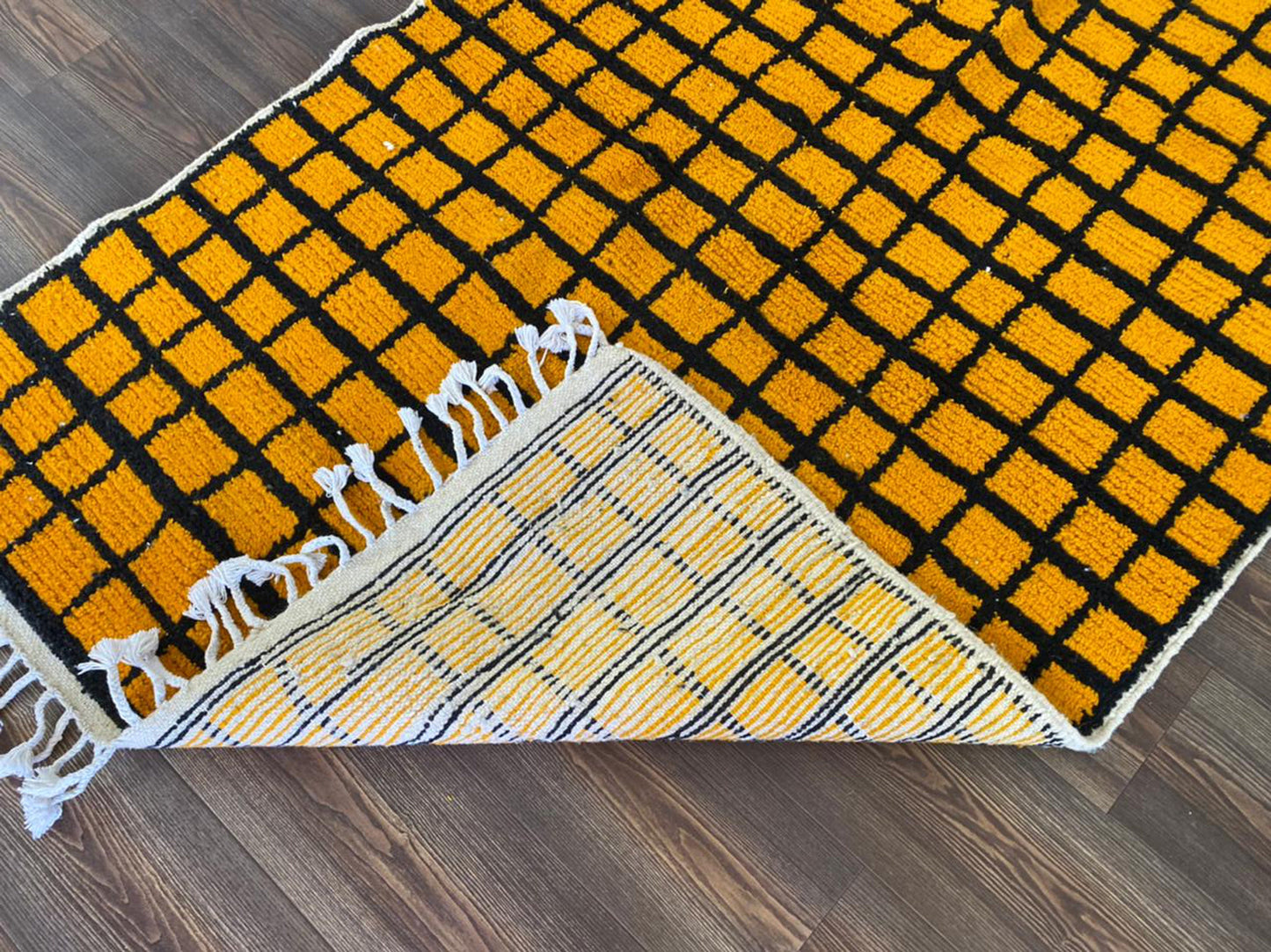 Tapis marocain tissé à la main jaune et noir quadrillé.