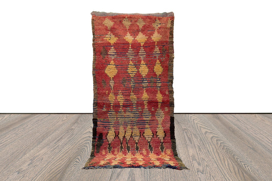 Tapis berbère marocain vintage 4x9 à motifs de losanges rouges et jaunes délavés.