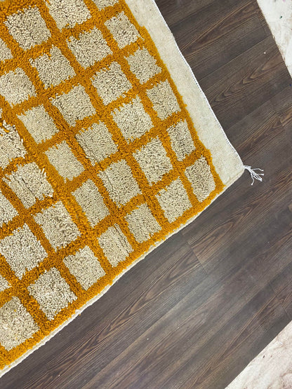 Moroccan orange and white grid area rug.