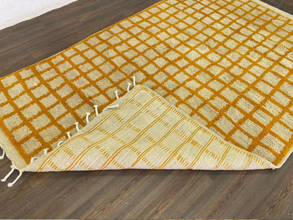 Moroccan orange and white grid area rug.