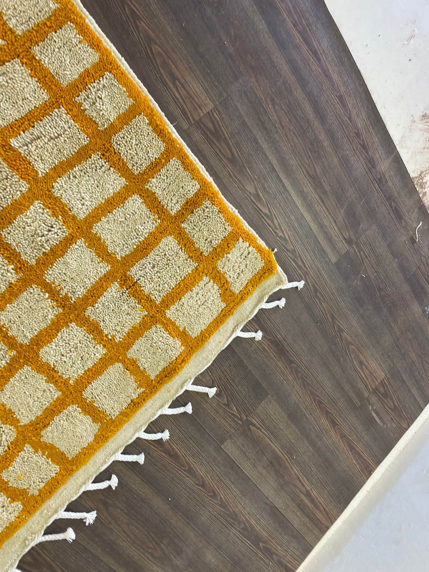 Moroccan orange and white grid area rug.