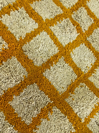 Moroccan orange and white grid area rug.