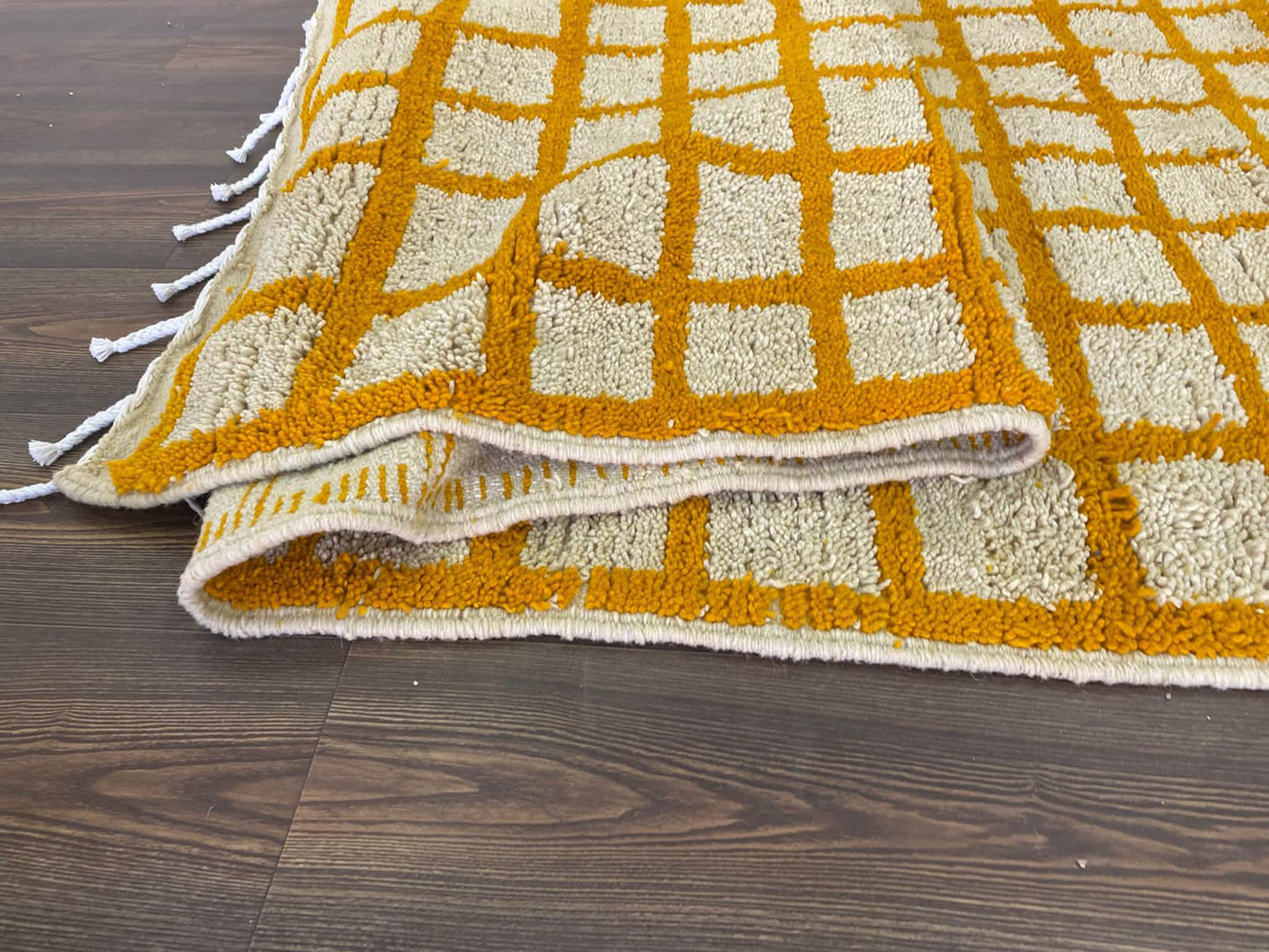 Moroccan orange and white grid area rug.